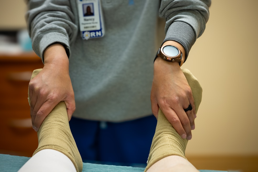 Sports medicine doctor examining patient knee before surgery. Photo by Judy Beth Morris on Unsplash