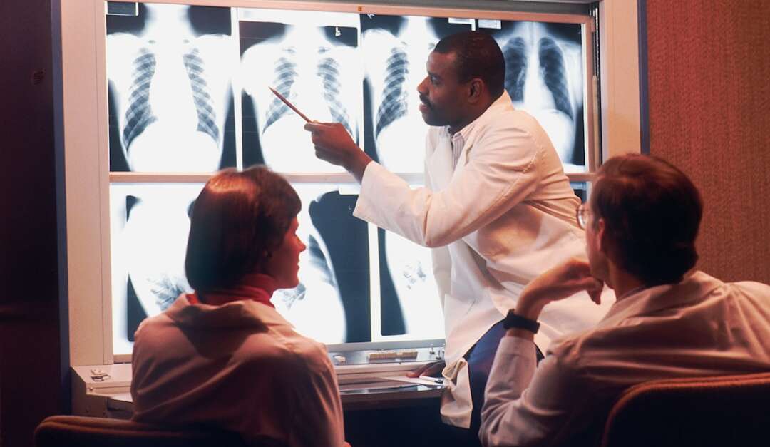 Orthopedic doctor examining X-rays with medical team at Barbour Orthopaedics clinic