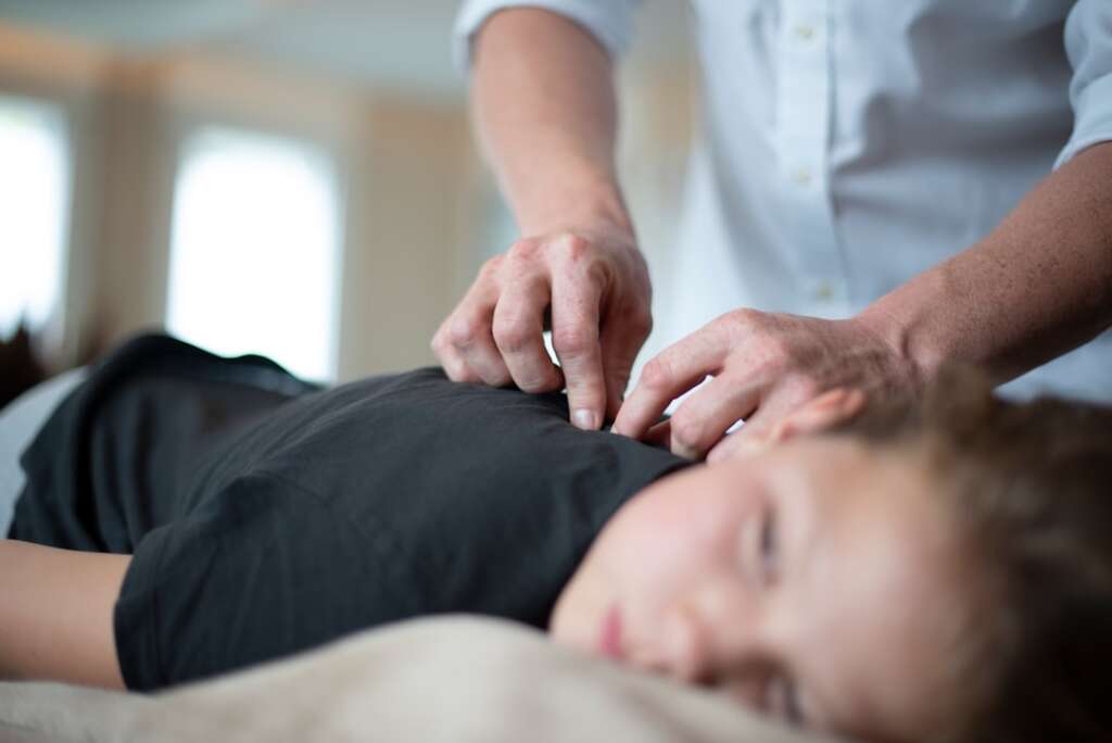Physical therapist performing manual neck therapy treatment for cervical spine conditions