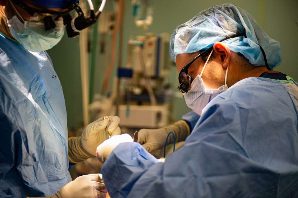 Surgeons performing a surgical procedure in modern operating room for spine treatment
