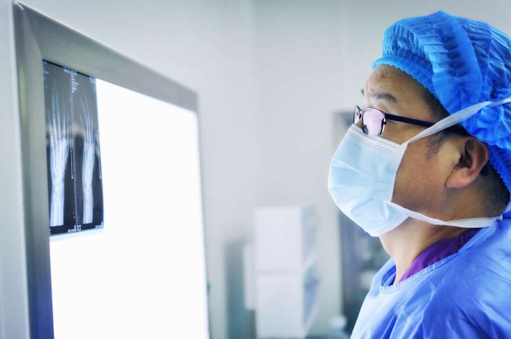 Doctor reviewing spinal imaging for injection therapy procedure