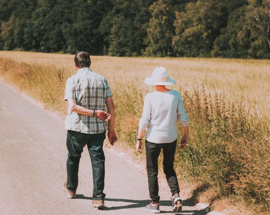 Active senior couple walking outdoors together representing successful recovery and return to mobility