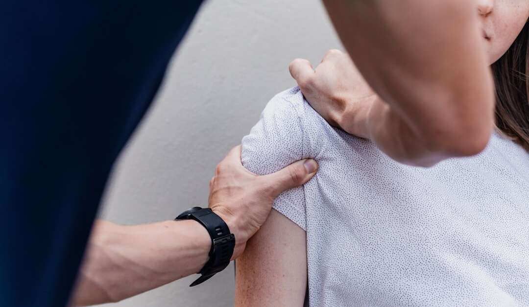 Orthopedic doctor examining patient's shoulder and arm for injury assessment