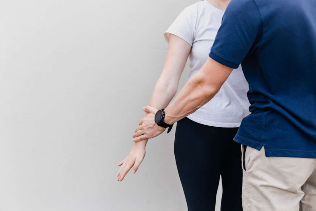 Physical therapist working with patient on shoulder rehabilitation exercises and range of motion