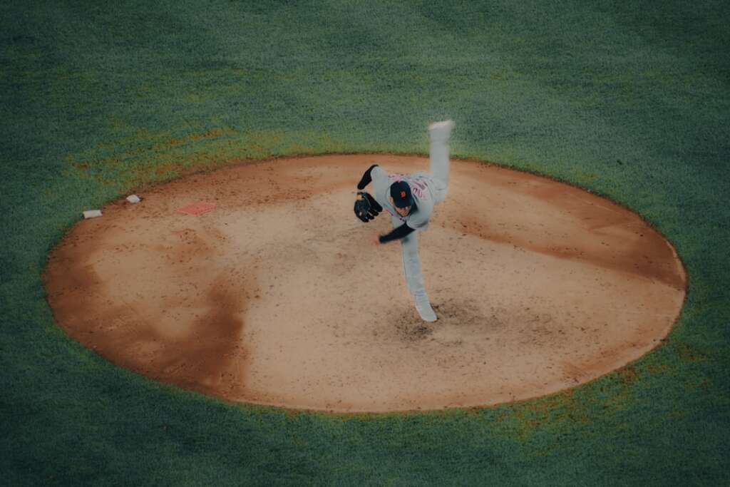 Baseball pitcher throwing from mound showing overhead shoulder motion that can cause labrum tears
