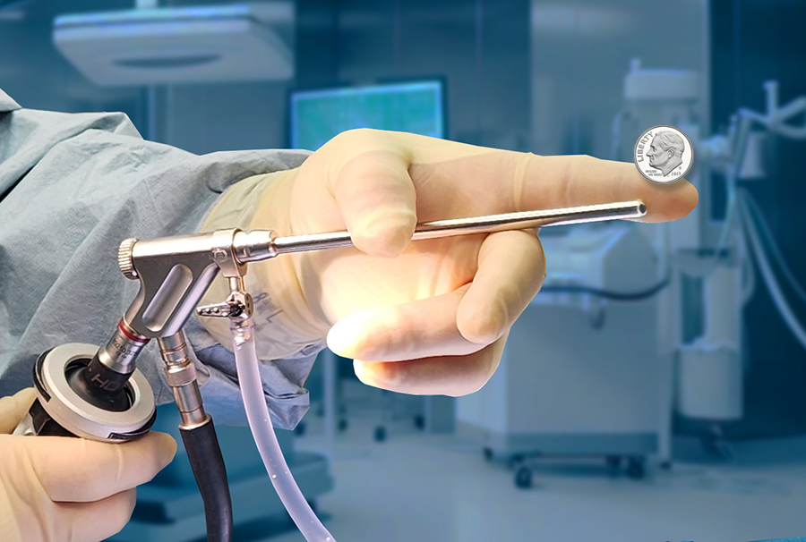 Surgeon's gloved hand holding a surgical instrument with a coin for scale in an operating room.