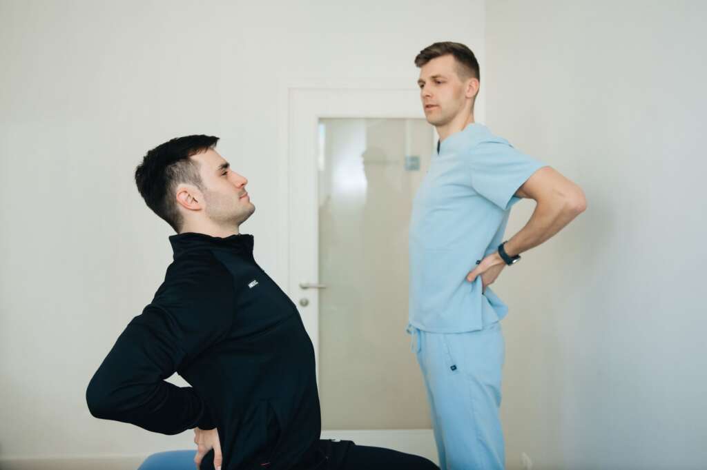Physiotherapist instructing a patient on back exercises in a clinic — non-surgical treatment for back pain