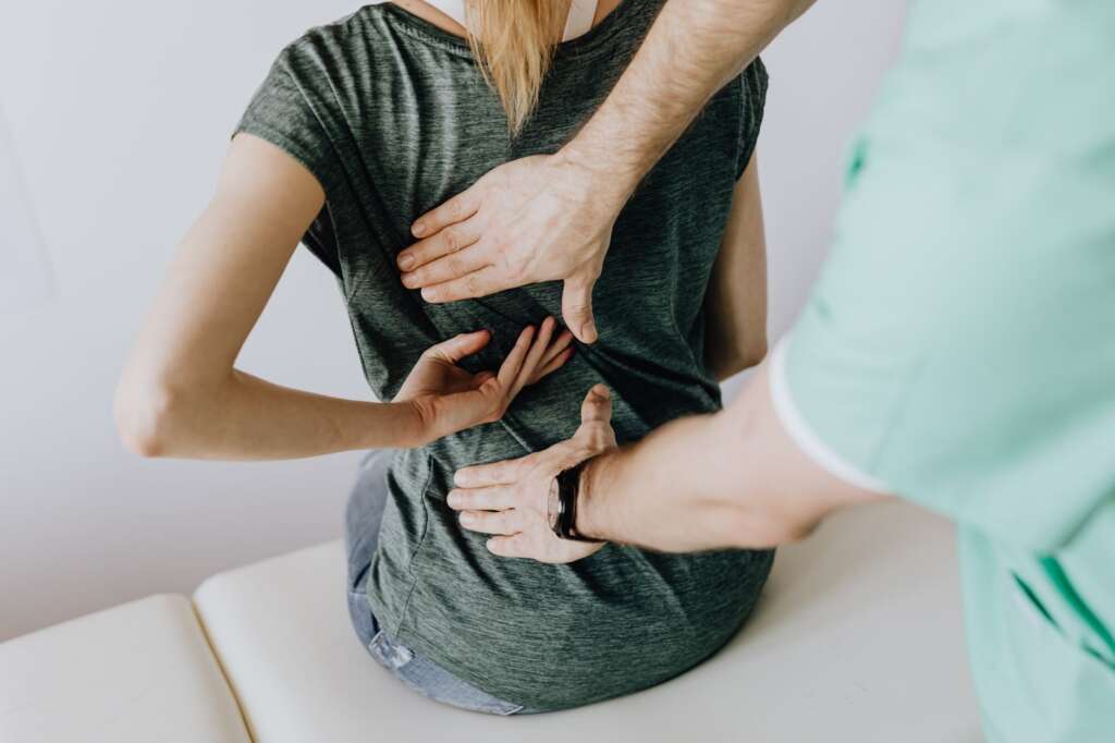 Orthopedic specialist examining patient's spine and back pain at Jacksonville orthopedic clinic