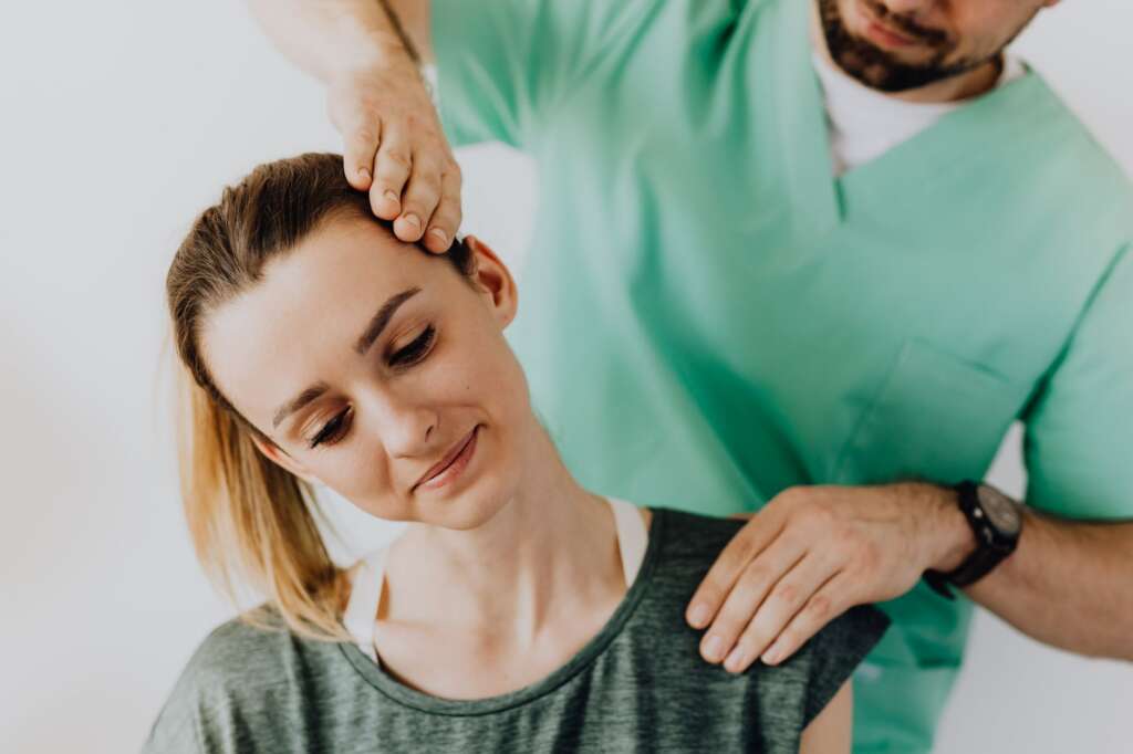 pexels-photo-4506217jpg - Barbour Orthopaedics & Spine Physical therapist performing therapeutic neck treatment and stretching on a patient