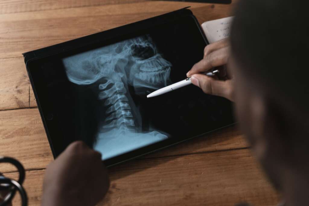 pexels-photo-5452223jpg - Barbour Orthopaedics & Spine Doctor reviewing a cervical spine X-ray on a digital tablet for diagnostic purposes