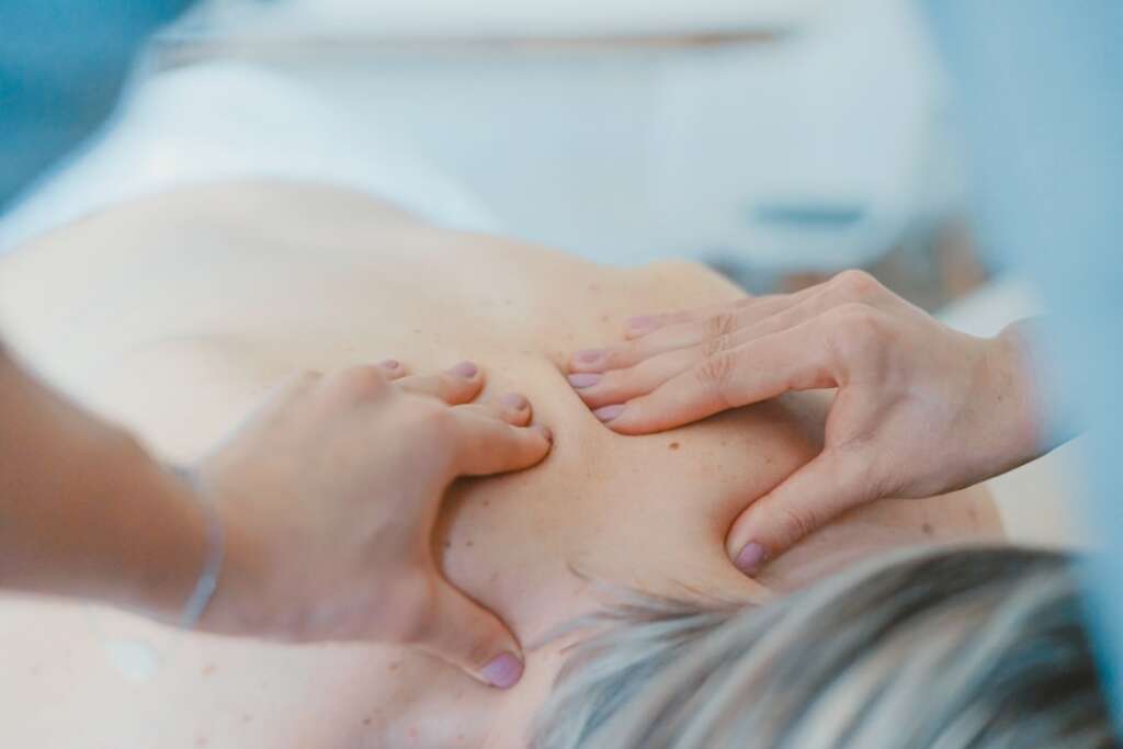 photo-1519824145371-296894a0daa9jpg - Barbour Orthopaedics & Spine Therapist performing hands-on neck and upper back treatment on a patient - neck pain treatment options
