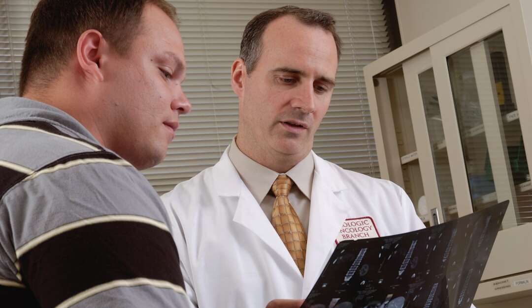 Orthopedic surgeon reviewing imaging scans with a patient during a consultation