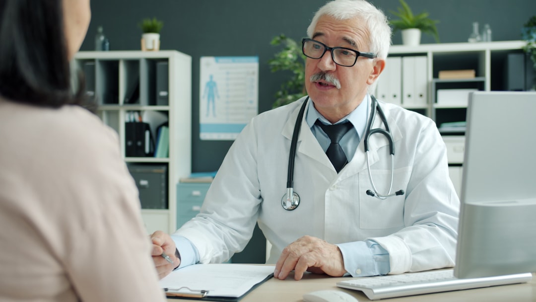 Friendly senior orthopedic doctor consulting with a patient in a clinic office. Photo by Unsplash.