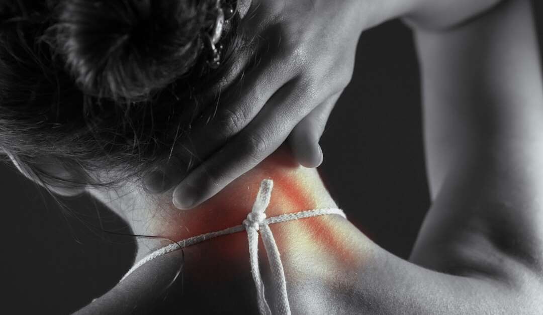 Woman experiencing acute neck pain, holding the back of her neck with highlighted pain area - neck pain specialist Atlanta Georgia